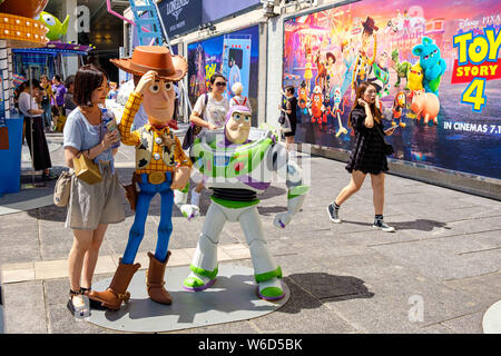 Hong Kong, Chine. 26 juillet, 2019. Une femme possède à côté des répliques de shérif Woody et Buzz Lightyear pendant le Carnaval.Toy Story 4 est célébré avec un carnaval sur le thème des différents jeux et défis par Hong Kong Harbour City et Disney à Hong Kong, Chine. Crédit : Daniel Fung/SOPA Images/ZUMA/Alamy Fil Live News Banque D'Images