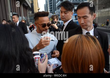 La pilote de F1 Lewis Hamilton de Mercedes, signe des autographes pour les fans dans la rue à Shanghai, Chine, 10 avril 2018. Banque D'Images