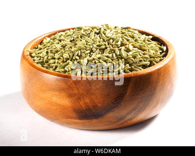 Les graines de fenouil (Foeniculum vulgare) dans une tasse en bois sur fond blanc Banque D'Images