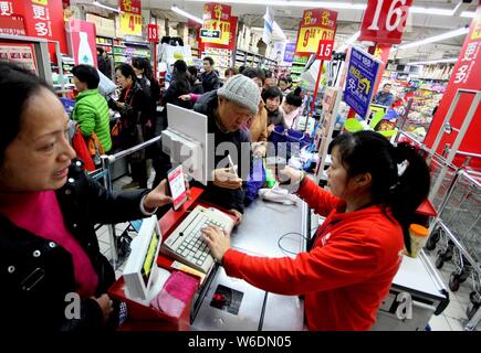 --FILE--les clients Chinois la queue pour payer leurs achats avec des bons a obtenu à partir de l'application mobile d'Alibaba est en ligne sur hors ligne (O2O) une plate-forme de service K Banque D'Images