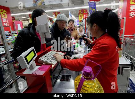 --FILE--les clients Chinois la queue pour payer leurs achats avec des bons a obtenu à partir de l'application mobile d'Alibaba est en ligne sur hors ligne (O2O) une plate-forme de service K Banque D'Images