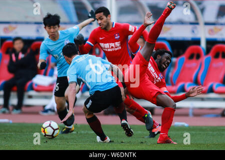 Un joueur de Dalian Yifang défis joueur de football brésilien, Alan Kardec, centre, et joueur de football brésilien Fernandinho Henrique, droite, de Chon Banque D'Images