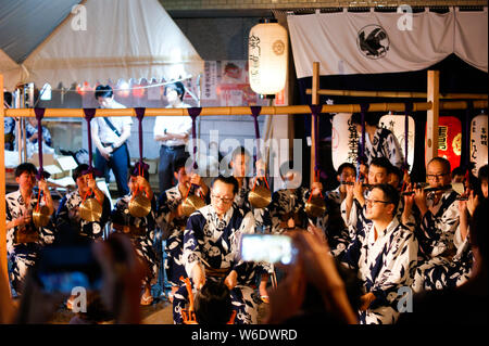 Groupe de musiciens jouant de la flûte traditionnelle japonaise et bell musique dans un petit festival Banque D'Images