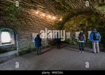 Les panneaux d'interprétation sur l'histoire de Château de Scalloway, Shetland, dans un cellier du Château. Banque D'Images