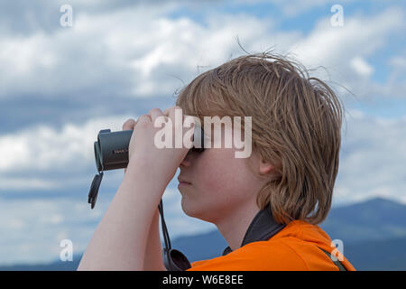 Garçon regardant à travers des jumelles, Grafenau, Parc National, Bayerischer Wald, Bavière, Allemagne Banque D'Images