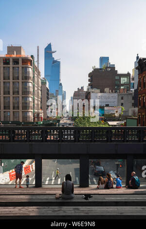 High Line New York, vue arrière de gens assis sur les !0ème Avenue surplombent en haute ligne dans le quartier de Chelsea, Manhattan, New York. Banque D'Images