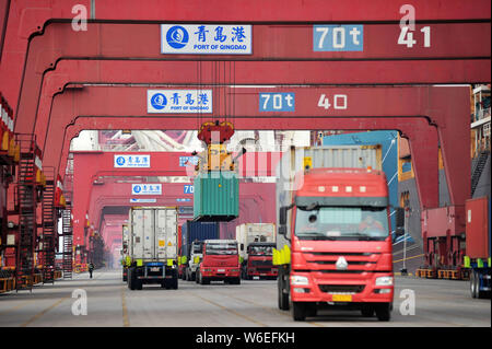 Les conteneurs de transport des camions pour être expédiés à l'étranger, sur un quai du port de Qingdao en Qingdao city, province de Shandong en Chine orientale, le 8 mars 2018. Chi Banque D'Images