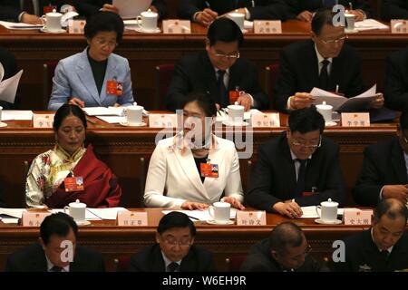 La nageuse chinoise Ye Shiwen, centre, et d'autres adjoints suivent la quatrième réunion plénière de la première session de la 13e Assemblée populaire nationale ( Banque D'Images