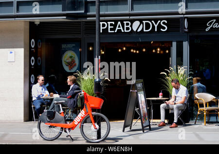 Londres, Angleterre, Royaume-Uni. Location de vélos en libre-saut de l'extérieur d'un Uber cafe Banque D'Images