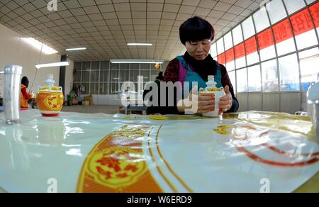 --FILE--Un travailleur chinois produit des bouteilles en porcelaine Xia occidentaux utilisés pour contenir l'esprit chinois d'une usine à Wuwei ville du nord-ouest de la Chine, au Gansu Banque D'Images