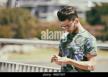 Brisbane, Australia-October 01,2018 : hipster connecté à son téléphone cellulaire. Banque D'Images