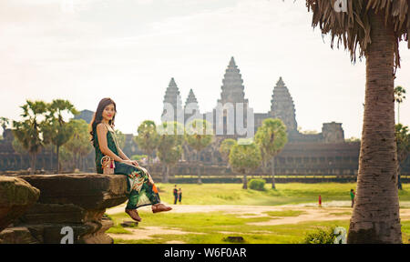 Portrait de Candide asiatique brune femelle solo traveler avec à Siem Reap, Cambodge. Il y a un célèbre temple d'Angkor Wat dans l'arrière-plan. Banque D'Images