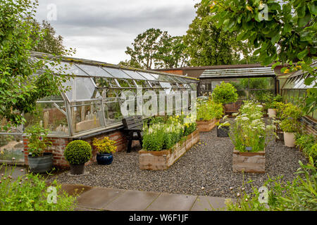 INVERNESS ECOSSE LES JARDINS BOTANIQUES PATIO AVEC DES CHAISES DES SERRES ET UNE VARIÉTÉ DE FLEURS DANS DES CONTENANTS EN BOIS Banque D'Images