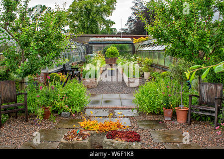 INVERNESS ECOSSE LES JARDINS BOTANIQUES PATIO AVEC DES CHAISES DES SERRES ET DES FLEURS DANS DES CONTENANTS EN BOIS Banque D'Images