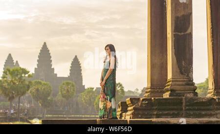 Portrait de Candide asiatique brune femelle solo traveler avec à Siem Reap, Cambodge. Il y a un célèbre temple d'Angkor Wat dans l'arrière-plan. Banque D'Images