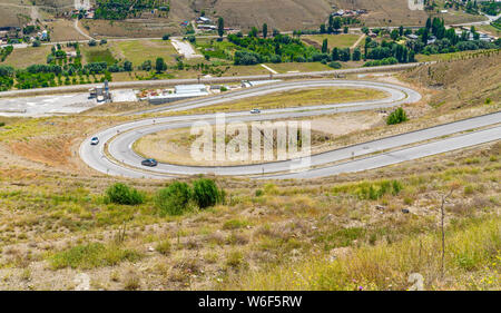Les voitures qui circulent sur la route en zigzag, courbe ou la rue sur la colline de Imrahor Vallée, juste près de Muhye Village à Cankaya, Simpas maisons. Ankara, Turquie. Banque D'Images
