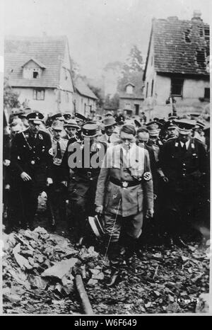 Adolf Hitler, accompagné d'autres responsables allemands, sinistrement inspecte les dommages causés par les bombes dans une ville allemande en 1944, dans ce film allemand capturé par l'US Army Signal Corps sur le front de l'ouest. ; Anglais : l'image fixe à partir d'un film représente Adolf Hitler marche à travers les ruines de Öschelbronn le 14 septembre 1933. Le 10 septembre 1933 un incendie a détruit 184 111 bâtiments et structures endommagées, résultant en 357 de 1421 habitants devenir sans-abri. Hitler arrive dans Öschelbronn à autour de 13:45 à gauche et Böblingen à environ 14:30. L'image a été utilisée à des fins de propagande par les Allemands.[1][2][3 Banque D'Images