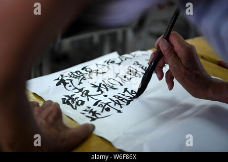 (190801) -- HEXIAN, 1er août 2019 (Xinhua) -- Ye Lianping écrit un avis revoir à la college student volontaires dans la salle de classe de la "maison d'enfants à l'arrière gauche' à Buchen Village de Hexian, comté de la province de l'Anhui en Chine orientale, le 30 juillet 2019. Ye Lianping, 92 ans, enseignant à la retraite à Buchen Village de Hexian County, mis en place la "maison pour la direction à gauche derrière les enfants' en 2000 pour leur enseigner des leçons d'anglais gratuitement. Comme la plupart des jeunes travaillent loin de là, les anciens et les enfants sont restés dans le village. N'ayant pas d'enfant lui-même, Ye vit avec son épouse dans un bidonville construit maison 30 Banque D'Images