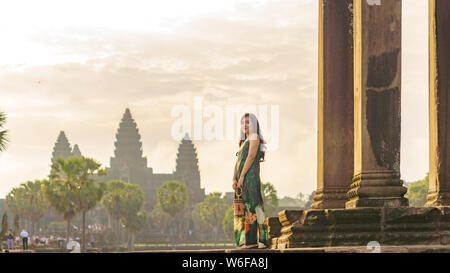 Portrait de Candide asiatique brune femelle solo traveler avec à Siem Reap, Cambodge. Il y a un célèbre temple d'Angkor Wat dans l'arrière-plan. Banque D'Images