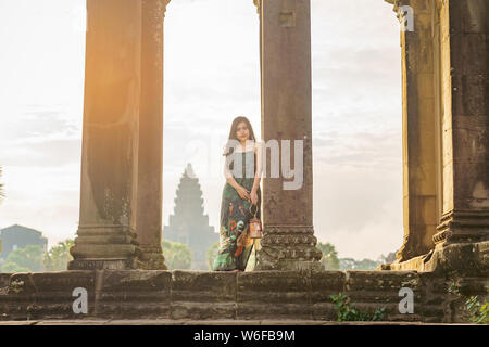 Portrait de Candide asiatique brune femelle solo traveler avec à Siem Reap, Cambodge. Il y a un célèbre temple d'Angkor Wat dans l'arrière-plan. Banque D'Images