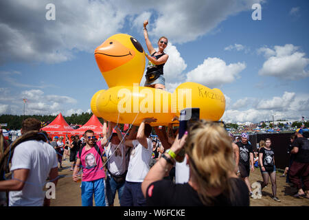 Kostrzyn Nad Odra, Pologne. 06Th Aug 2019. Un visiteur est assis sur un énorme canard en caoutchouc sur le terrain de la Pol'et'Rock Festival et est porté par un groupe d'hommes. Le festival gratuit pour les visiteurs aura lieu du 01.08.2019 au 03.08.2019 pour la 25e fois à Kostrzyn nad Odra. Credit : Gregor Fischer/dpa/Alamy Live News Banque D'Images