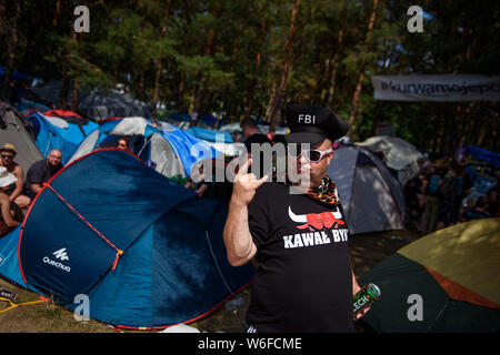 Kostrzyn Nad Odra, Pologne. 06Th Aug 2019. Un visiteur gesticule avec une bière à la main au bord du camping sur le terrain de la Pol'et'Rock Festival. Le festival gratuit pour les visiteurs aura lieu du 01.08.2019 pour la 25e fois, jusqu'à 03.08.2019 à Kostrzyn nad Odra. Credit : Gregor Fischer/dpa/Alamy Live News Banque D'Images