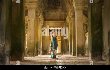 Portrait de Candide asiatique brune femelle solo traveler avec à Siem Reap, Cambodge. Il y a un célèbre temple d'Angkor Wat dans l'arrière-plan. Banque D'Images