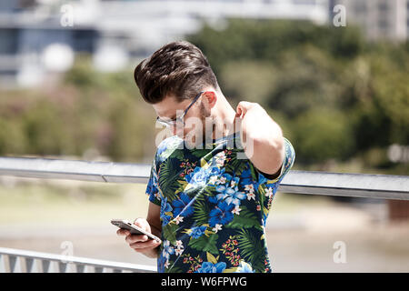 Brisbane, Australia-October 01,2018 : hipster connecté à son téléphone cellulaire. Banque D'Images