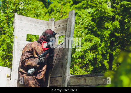 Sport Paintball player en uniforme de protection et masque jouant avec des armes d'extérieur. Banque D'Images