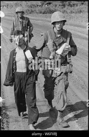 Capturé Viet Cong. Un prisonnier Viet Cong capturés lors de l'opération Double Eagle, 20 miles au sud de la province de Quang Ngai, le Vietnam est amené dans la région de la collection par des Marines. Les détenus ont les yeux bandés et attaché à prévenir les tentatives d'évasion. La carte sur la chemise de pyjama noir du prisonnier se rapporte aux circonstances de sa capture. Banque D'Images