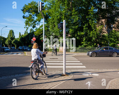 Les cyclistes en attente de rue transversale au passage pour piétons, Strasbourg, Alsace, France, Europe, Banque D'Images