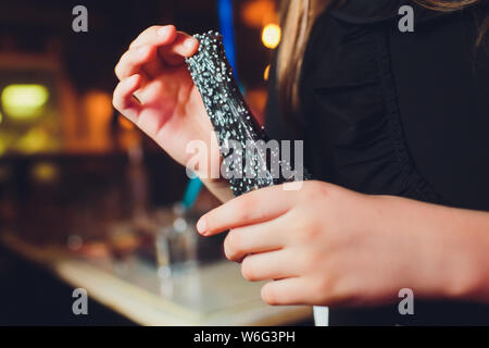 Femme tenant le jouet populaire anti-stress pour les mains, de mâcher de la gomme pour les mains, de mucus. Couleur métallique. Jeux pour enfants et adultes. Banque D'Images