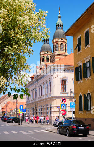 Sibiu, Roumanie - 12 juillet 2019 : la cathédrale Holy Trinity (Catedrala Sfanta Treime din Sibiu) et un grand groupe de touristes sur le trottoir près d'elle, en b Banque D'Images