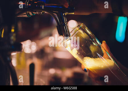 Main de bartender pouring une grande bière blonde au robinet. Banque D'Images