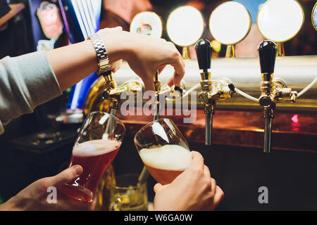 Main de bartender pouring une grande bière blonde au robinet. Banque D'Images