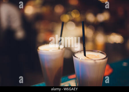 Deux de délicieux milk-shakes icecream épais garnis de chocolat et menthe et servi dans de grands verres réfrigérés sur un petit plateau en bois Banque D'Images