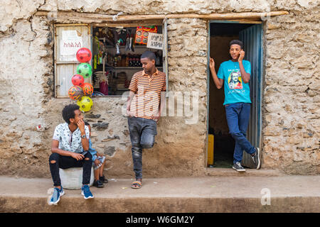 Les jeunes hommes éthiopiens à l'extérieur d'un magasin ; Gondar, région d'Amhara, en Éthiopie Banque D'Images