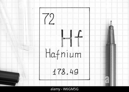 Le tableau périodique des éléments. Élément chimique Hf hafnium d'écriture avec un stylo noir, tube à essai et pipette. Close-up. Banque D'Images