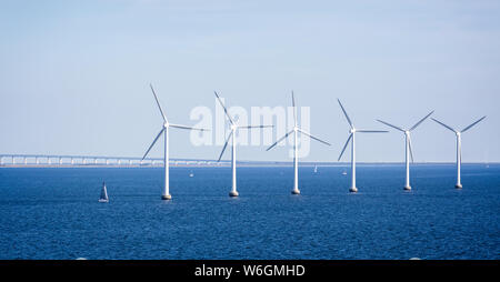 Parc éolien offshore en mer Baltique au large de Copenhague, au Danemark avec le Pont de l'Oresund en arrière-plan le 18 juillet 2019 Banque D'Images