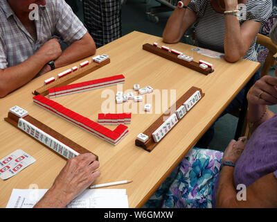 Mah-Jong Club, hommes et femmes jouant le jeu chinois Mah Jong dans une bibliothèque publique, en Angleterre, UK. photo DON TONGE Banque D'Images