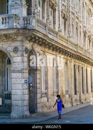 Une femme marche dans la rue près d'un bâtiment avec une façade très ornée, à La Havane, Cuba Banque D'Images