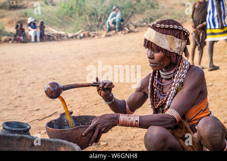 Hamer woman preparing a ceremonial verre dans un bull jumping cérémonie, qui lance un garçon dans la virilité, dans le village d'asile, vallée de l'Omo Banque D'Images