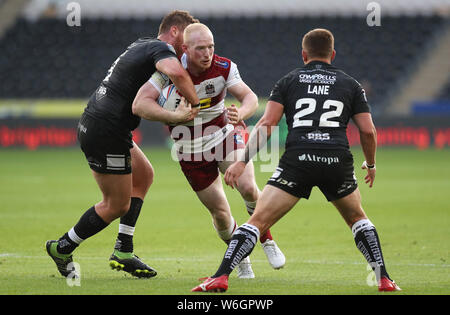 Wigan Warriors' Liam Farrell est abordé par Hull FC, Scott Taylor (à gauche) et Jordan Lane au cours de la Super League Betfred match au stade KCOM, Hull. Banque D'Images