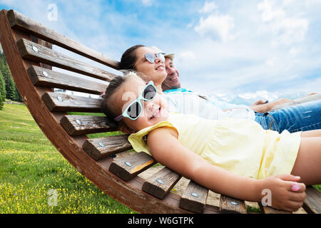 Famille avec peu de détente dans une chaise longue dans les montagnes Banque D'Images