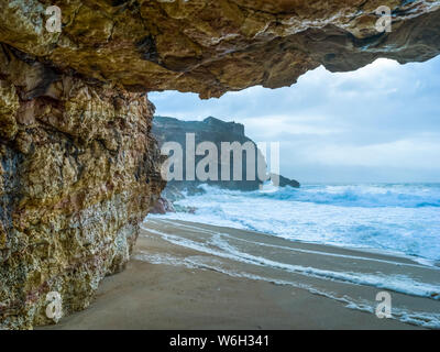 Nazare beach avec des falaises abruptes et des vagues ; Caldas da Rainha, Portugal, district de Leiria Banque D'Images