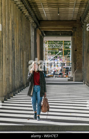 BERLIN, ALLEMAGNE - 26 septembre 2018 : Portrait d'une femme vêtu de rouge la marche, sourire et parler au téléphone sous l'ombre d'un des modèles Banque D'Images