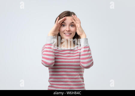 Jeune femme européenne souriant et jouant peekaboo. Banque D'Images