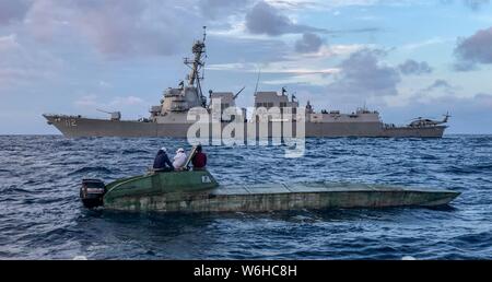 L'U.S Navy de la classe Arleigh Burke destroyer lance-missiles USS Michael Murphy intercepte un navire à profil bas avec des passeurs présumés dans l'océan Pacifique le 25 juillet 2019 au large de la Californie. Banque D'Images