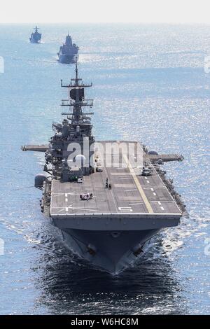 L'U.S Navy Wasp-classe d'assaut amphibie USS Bataan dirige une formation avec le San Antonio-Class dock de transport amphibie USS New York et la classe Harpers Ferry landing ship dock amphibie USS Oak Hill au cours d'une surface d'entraînement tactique avancé dans l'Océan Atlantique le 30 juillet 2019 au large de la côte de Virginie, USA. Banque D'Images