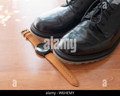 Paire de chaussures homme noir brillant et montres-officiel sur un bureau en bois Banque D'Images